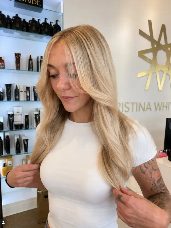 Long blonde layered haircut with a smooth blowout finish