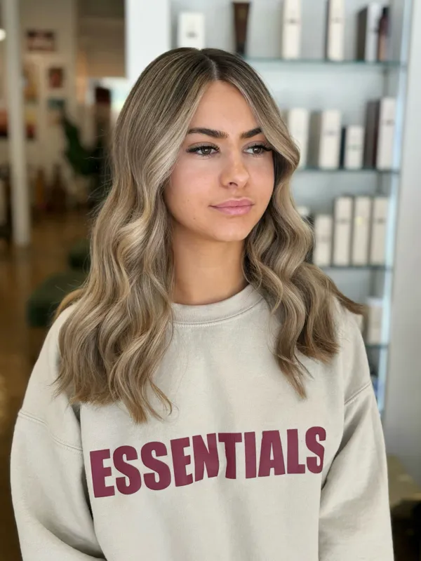Bright blonde money-piece highlights on light brown waves by Christina White Salon